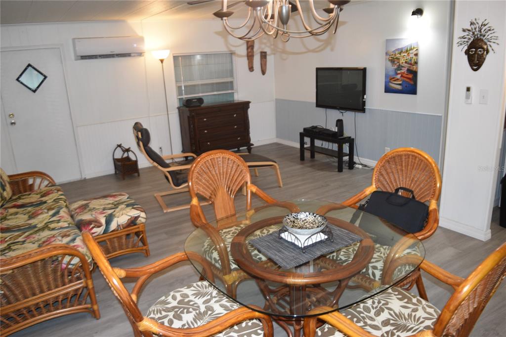 4407 Tucker Square New Port Richey, FL 34652 - Photo 32 of 69 a living room with furniture a flat screen tv and a dining table with the kitchen view