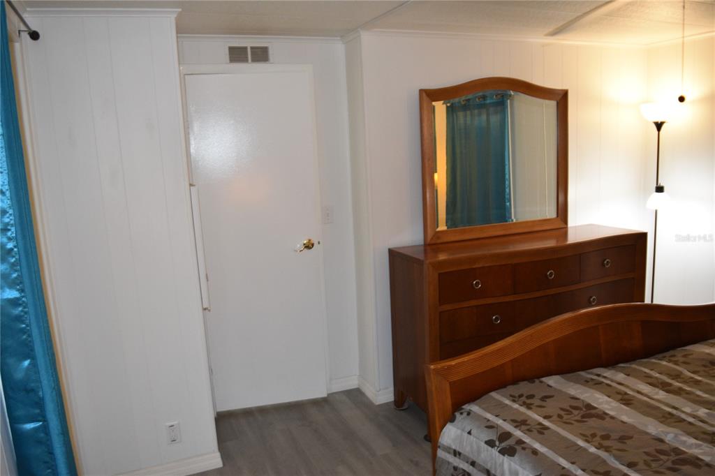 4407 Tucker Square New Port Richey, FL 34652 - Photo 57 of 69 a bedroom with a bed and a mirror on dresser