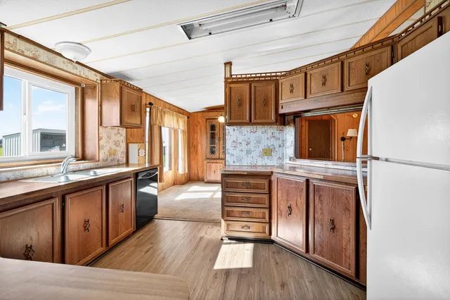 a kitchen with granite countertop a sink a stove and cabinets