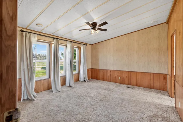 a view of a livingroom with a chandelier fan and closet area