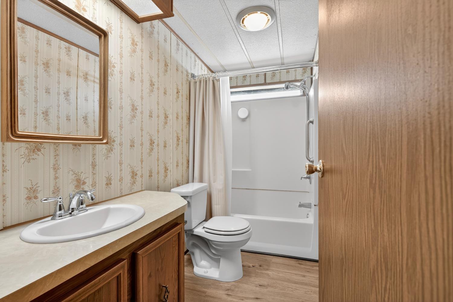 11900 Brandt Road Lockeford, CA 95237 - Photo 30 of 49 a bathroom with a granite countertop sink toilet and shower