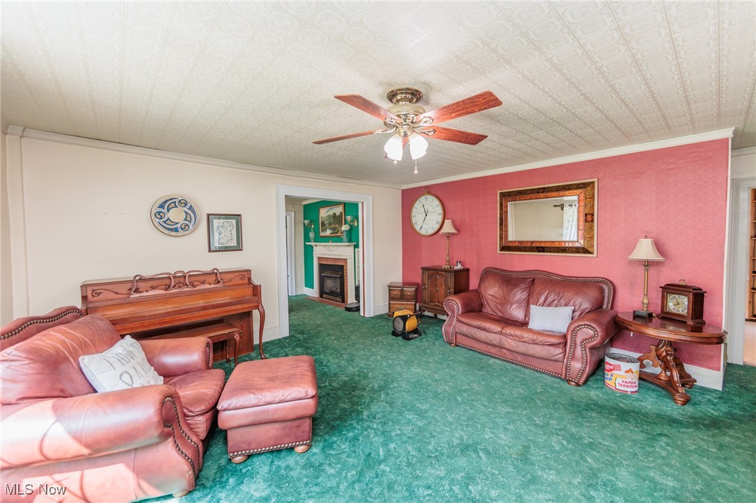 2550 North Ridge Road Vermilion, OH 44089 - Photo 27 of 50 Living room featuring ceiling fan, crown molding, and carpet flooring