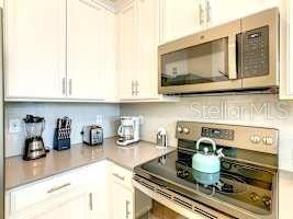 707 Ocean Course Avenue Davenport, FL 33896 - Photo 13 of 31 a kitchen with a stove and a microwave