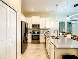 707 Ocean Course Avenue Davenport, FL 33896 - Photo 14 of 31 a kitchen with stainless steel appliances granite countertop a sink a stove and a refrigerator