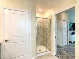 707 Ocean Course Avenue Davenport, FL 33896 - Photo 20 of 31 a bathroom with a glass shower door