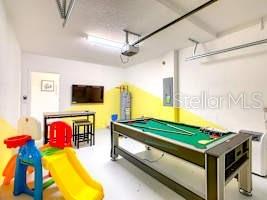 707 Ocean Course Avenue Davenport, FL 33896 - Photo 2 of 31 a living room with pool table and a flat screen tv