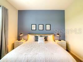 707 Ocean Course Avenue Davenport, FL 33896 - Photo 3 of 31 a bedroom with a large bed and a lamp