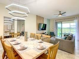 707 Ocean Course Avenue Davenport, FL 33896 - Photo 7 of 31 a dining room with furniture a flat screen tv and a large window