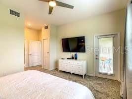 707 Ocean Course Avenue Davenport, FL 33896 - Photo 10 of 31 a spacious bedroom with a bed and a flat screen tv