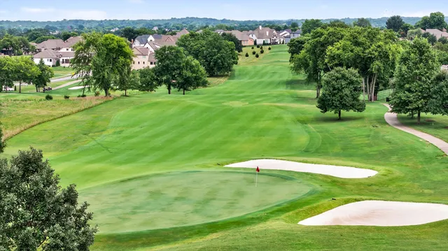 an aerial view of a golf course with a swimming pool