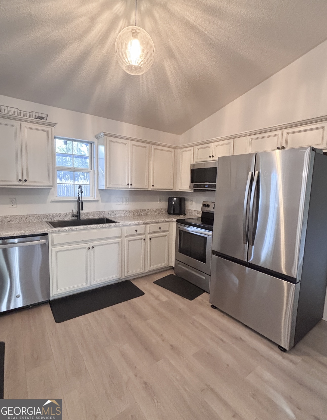 102 Honeysuckle Road Kingsland, GA 31548 - Photo 5 of 17 a kitchen with stainless steel appliances a refrigerator sink cabinets and wooden floor