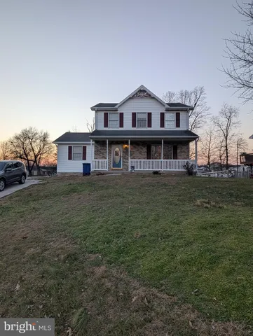 a view of a house with a big yard and large trees