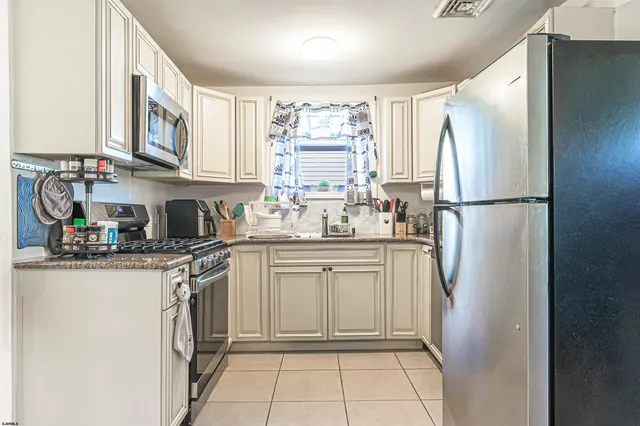 a kitchen with stainless steel appliances granite countertop a refrigerator sink and cabinets