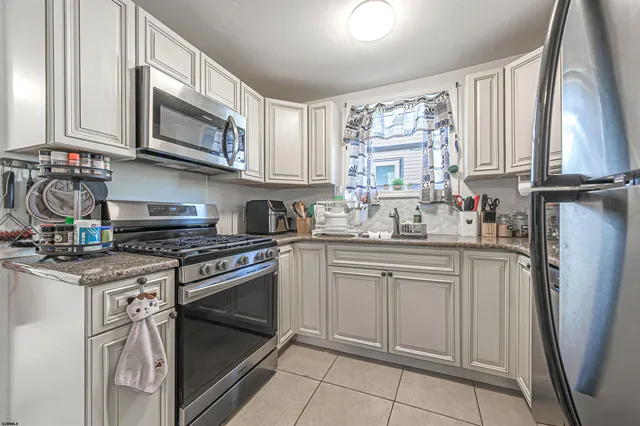 a kitchen with stainless steel appliances granite countertop a stove top oven a sink and dishwasher