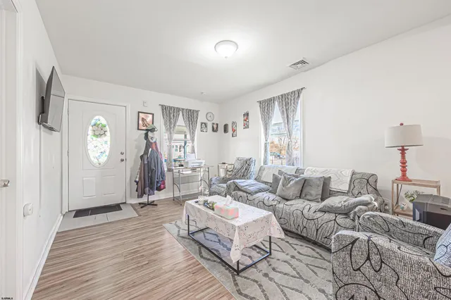 a living room with furniture and a wooden floor