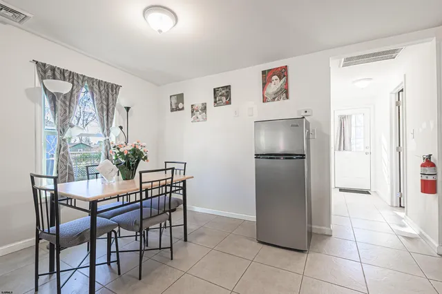 a dining room with furniture and refrigerator