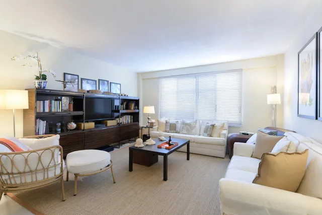 a living room with furniture a flat screen tv and a large window