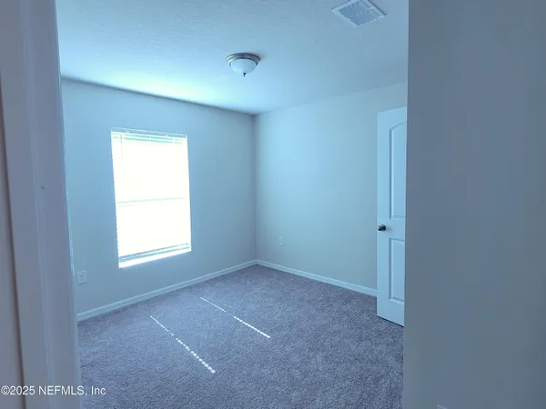 a living room with furniture a flat screen tv and kitchen view