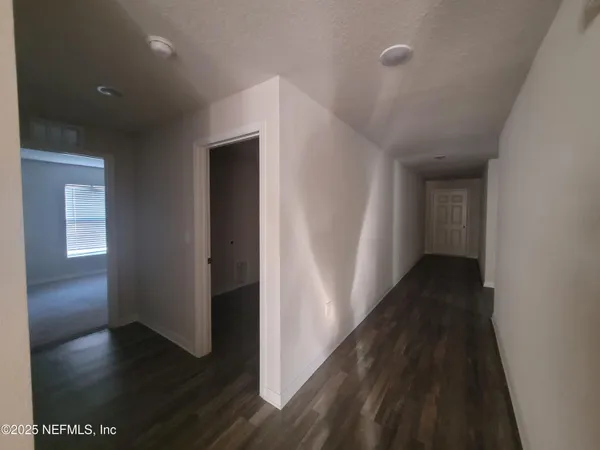 an empty room with a window and a fan