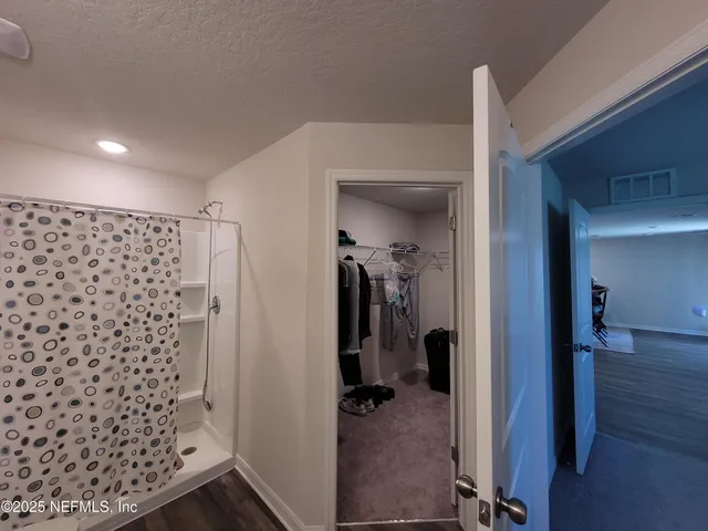 a living room with stainless steel appliances furniture and a flat screen tv