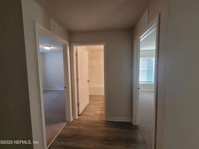 a view of a big room with wooden floor and a window