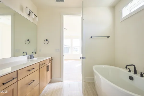 a bathroom with a sink double vanity granite tub shower and a mirror