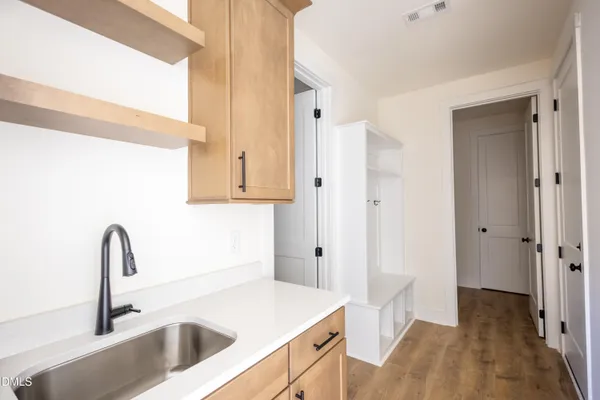 a view of an empty room with wooden floor fireplace and a window