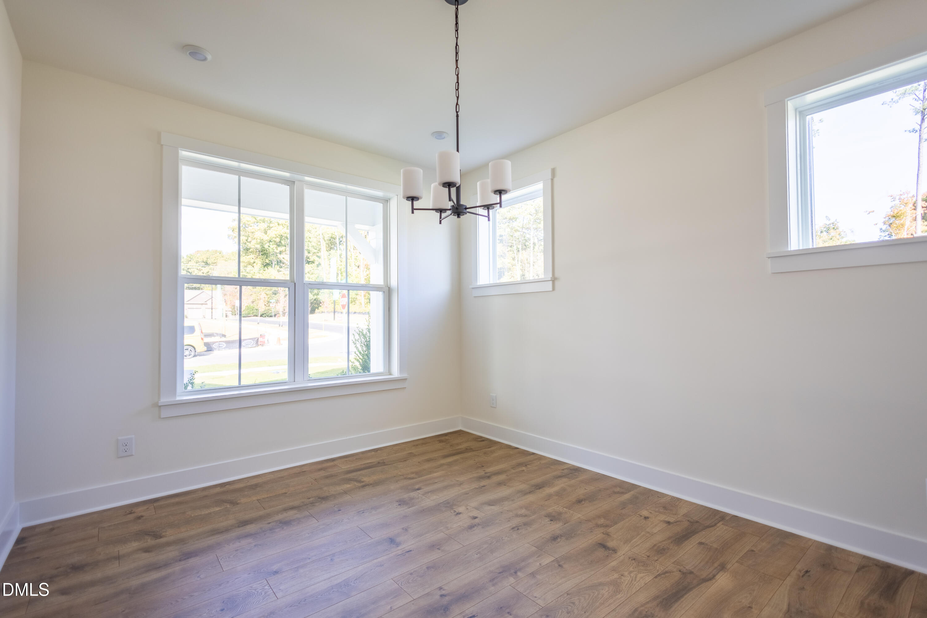 2001 Skipping Stone Drive Durham, NC 27705 - Photo 32 of 44 an empty room with wooden floor windows and ceiling fan