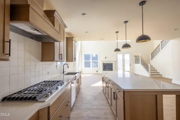 a kitchen with kitchen island a counter top space a sink stainless steel appliances and cabinets