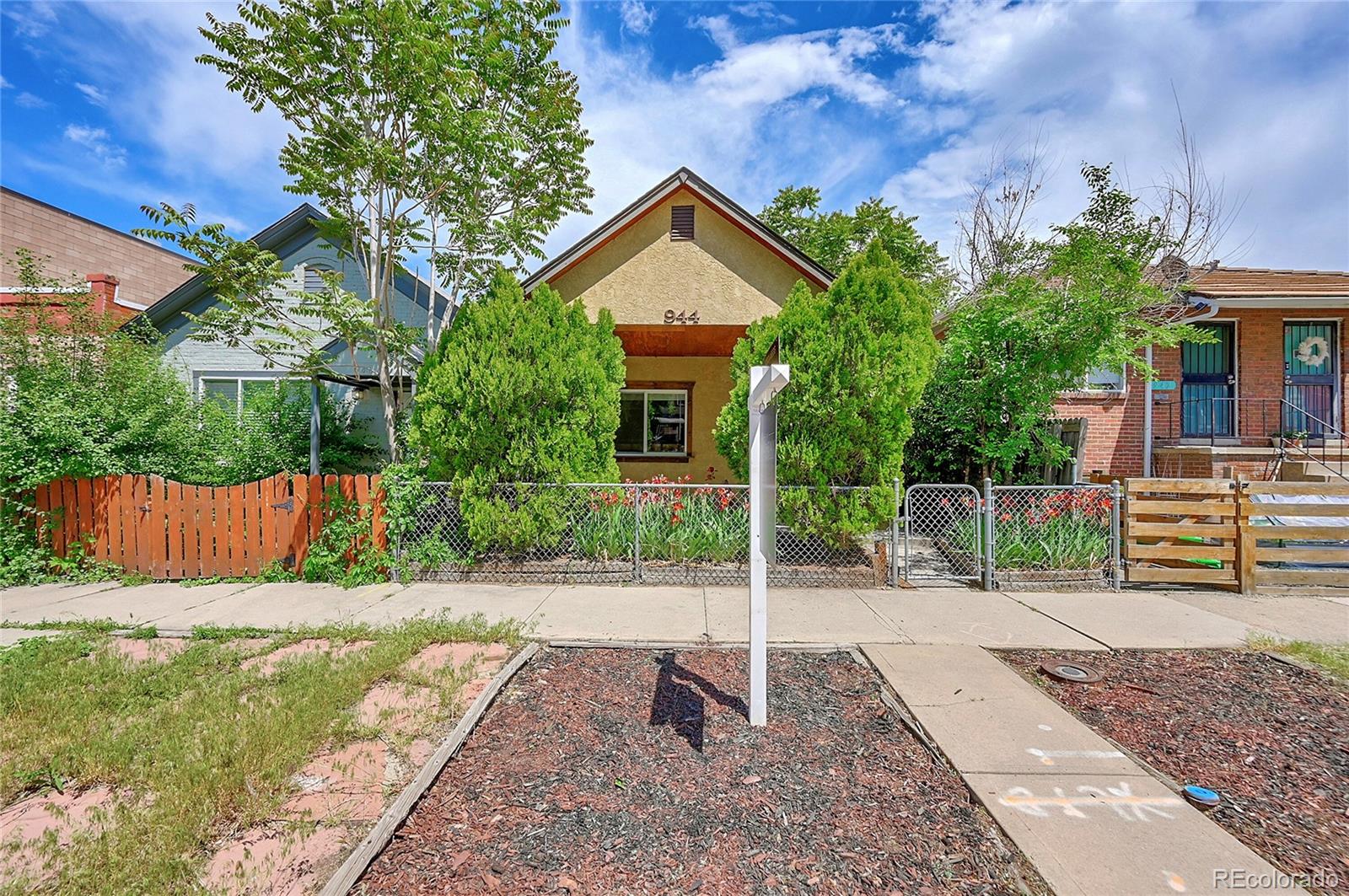 944 Inca Street Denver, CO 80204 - Photo 3 of 29 a view of a house with a small yard plants and a large tree