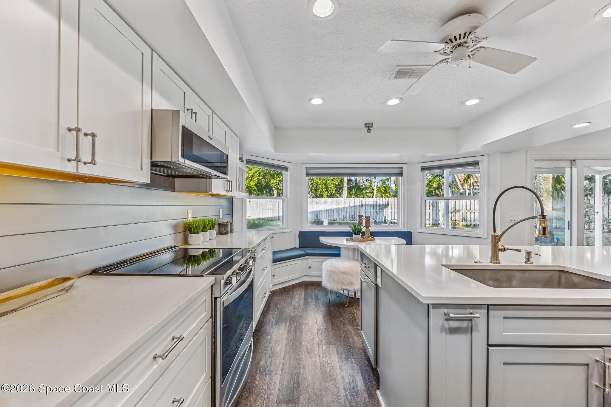 3069 Rio Bonita Street Indialantic, FL 32903 - Photo 7 of 48 a kitchen with kitchen island granite countertop a sink stainless steel appliances and white cabinets