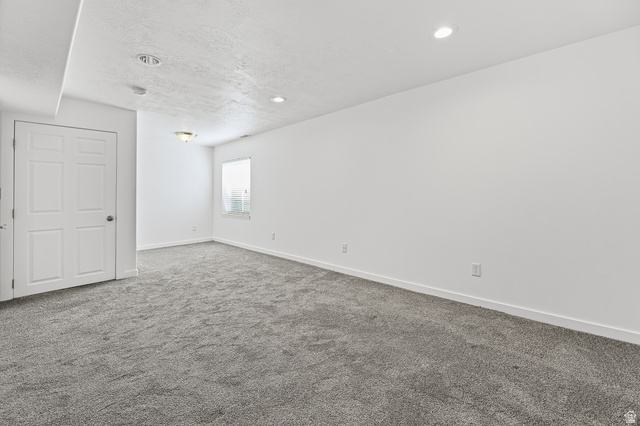 5525 Hampton Way Stansbury Park, UT 84074 - Photo 25 of 35 Spacious interior room featuring gray carpeting, white walls, recessed ceiling lights, and an overhead light fixture