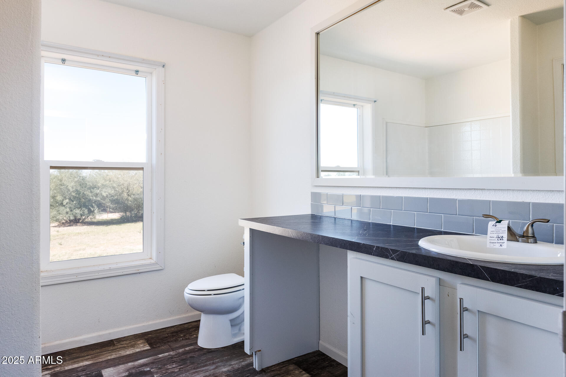 9713 South Thornton Road Casa Grande, AZ 85193 - Photo 22 of 42 a bathroom with a granite countertop sink a toilet and a window
