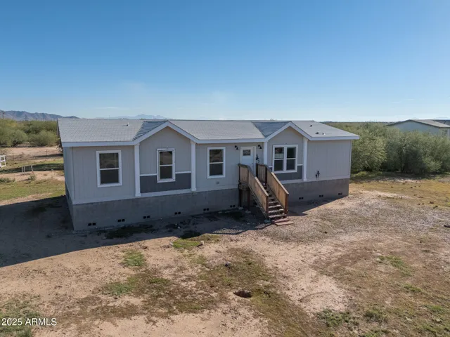 a view of a house with backyard and trees