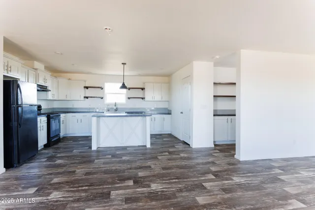 a kitchen with stainless steel appliances kitchen island granite countertop a refrigerator and a stove top oven