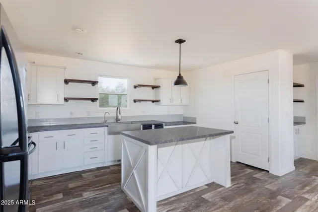 a kitchen that has a sink a stove and a wooden floor