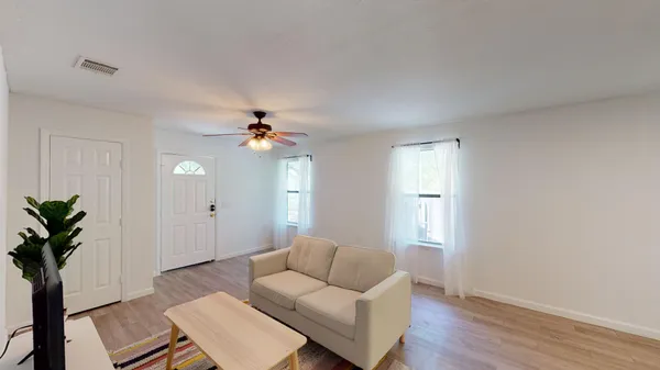 a living room with furniture and a potted plant