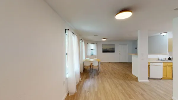 a view of a living room with wooden floor and a large window