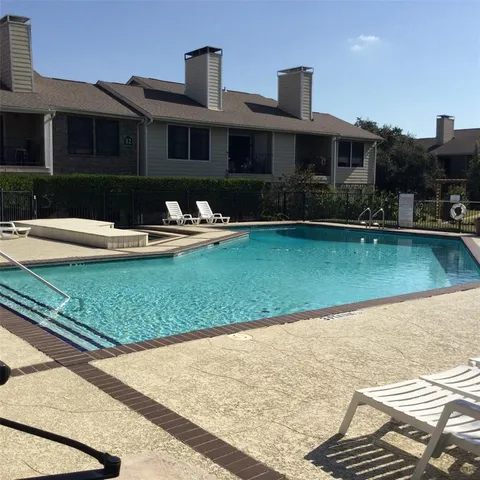 a front view of a house with swimming pool and a yard