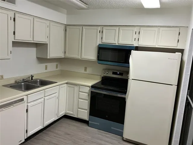 a kitchen with cabinets and white stainless steel appliances