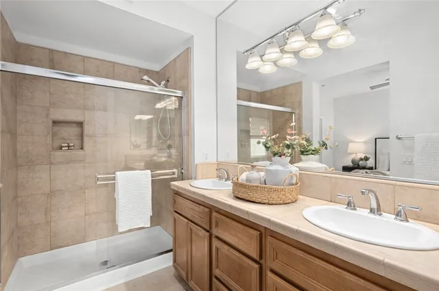 a bathroom with a granite countertop sink mirror and a bathtub