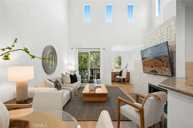 a living room with furniture a window and a flat screen tv
