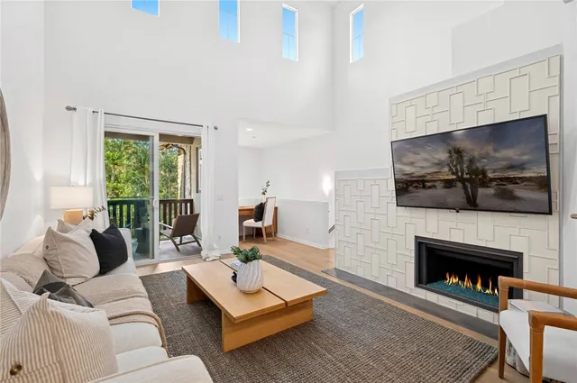 a living room with furniture a flat screen tv and a fireplace