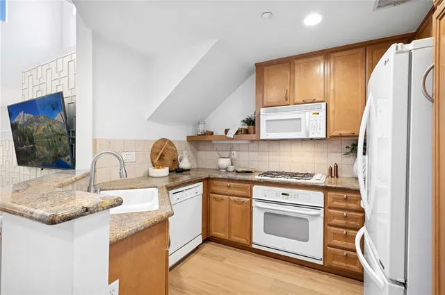 a kitchen with stainless steel appliances granite countertop a stove a sink and a refrigerator