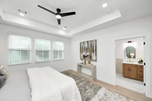 a bedroom with a bed next to a window with a dresser