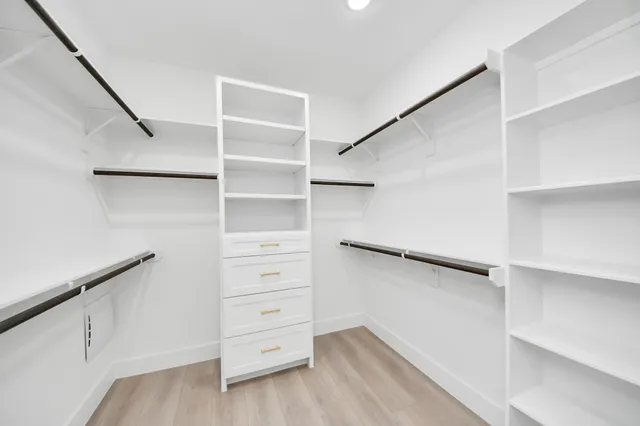 a view of walk in closet with empty racks