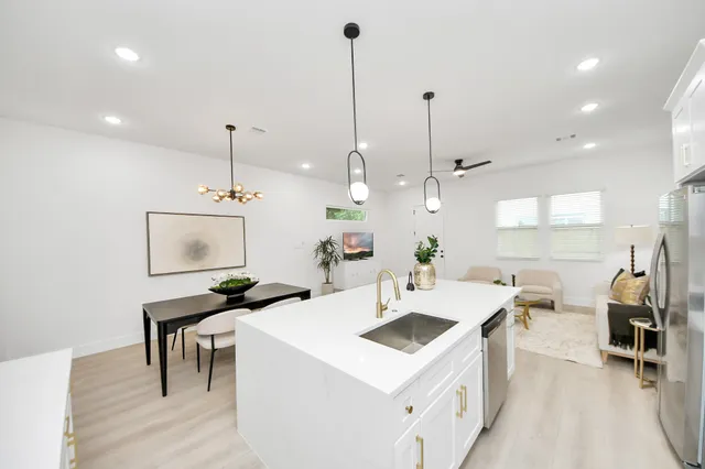 a kitchen with a sink a counter top space appliances and cabinets