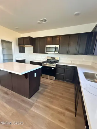 a kitchen with stainless steel appliances kitchen island granite countertop a sink counter space and cabinets