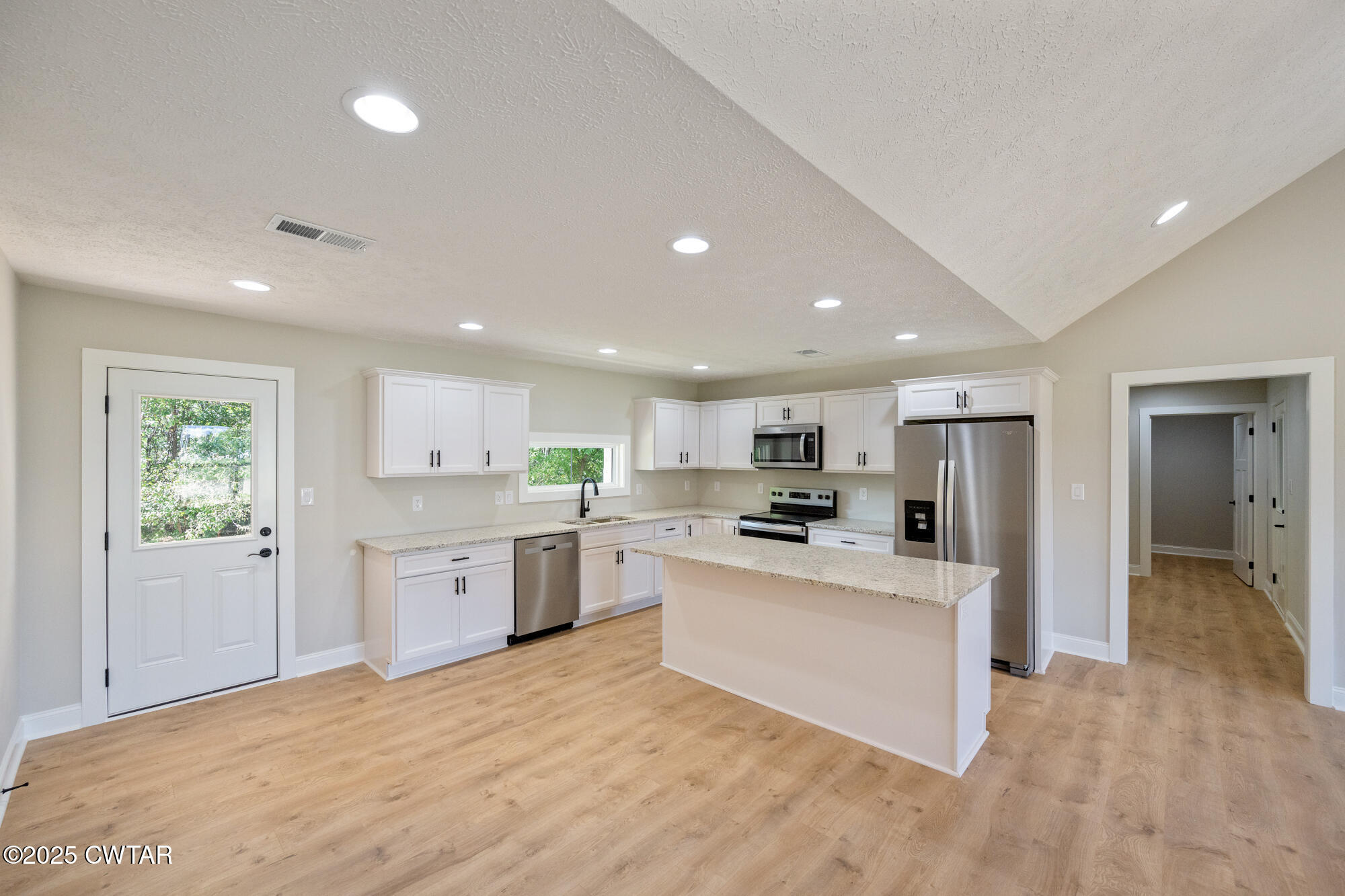 90 Derek Drive Lexington, TN 38351 - Photo 11 of 32 a large white kitchen with a stove a sink a refrigerator and a fireplace