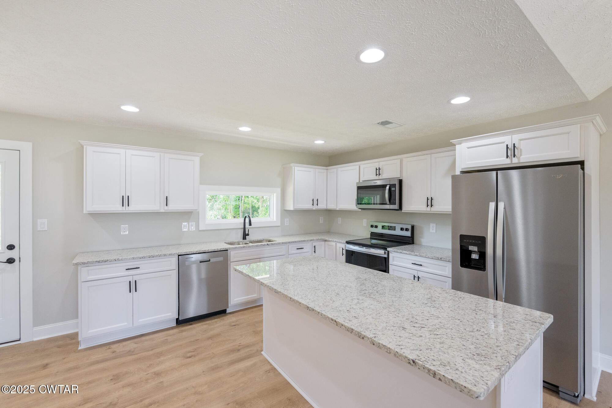 90 Derek Drive Lexington, TN 38351 - Photo 12 of 32 a large kitchen with stainless steel appliances lots of counter space sink refrigerator and cabinets
